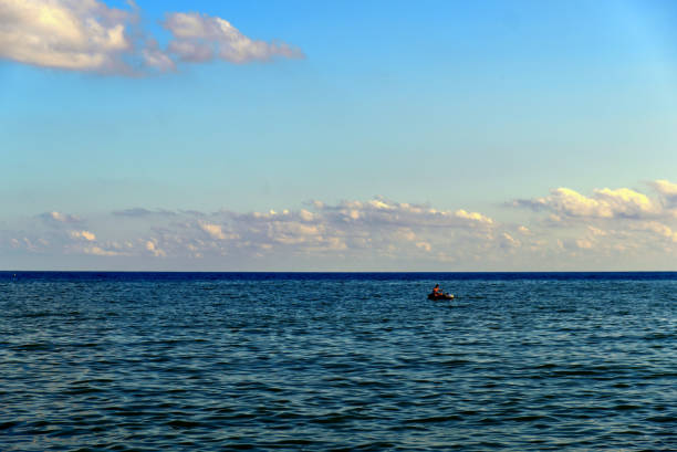 un piccolo gommoni con un naufrago perso in mezzo al mare - storm sailing ship sea shipwreck foto e immagini stock