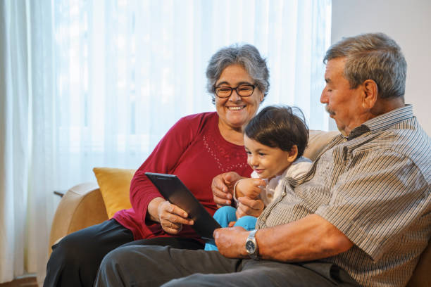 istock Grandparents with grandson at home using digital tablet, 4K Video footage 1346244710