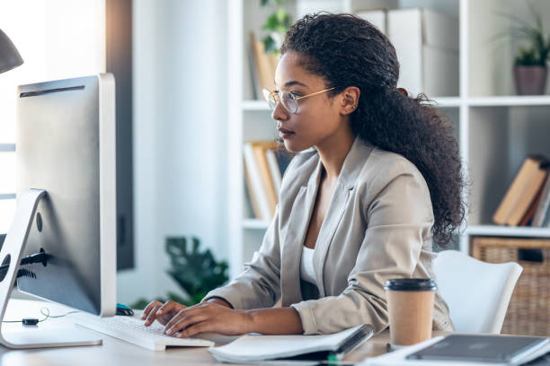 istock Elegant business woman working with laptop while checking and writing documents in the office. 1346245739