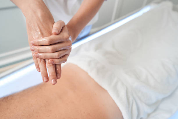 istock Masseuse rubbing hands with massage oil before procedure 1346245996
