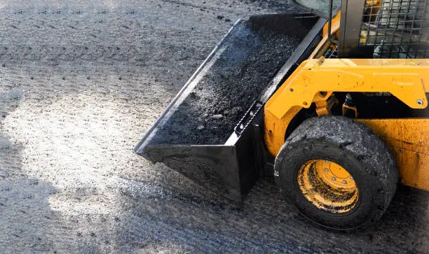 Front end loader carrying asphalt during paving