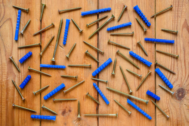 los tornillos y las clavijas están dispersos en el piso de madera. - screw wood dowel fastening fotografías e imágenes de stock