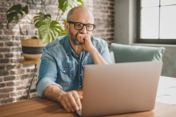 istock mature adult man working from office ( with laptop, paperwork, Negative Emotion) 1346249166