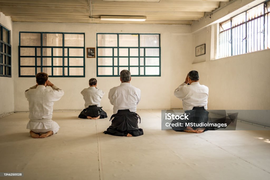 Four people meditating before aikido training Martial Arts Stock Photo