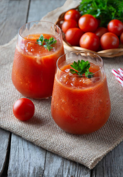 jus de tomate avec de la glace dans un verre, persil et tomate sur sac. - tomato juice drink celery juice photos et images de collection