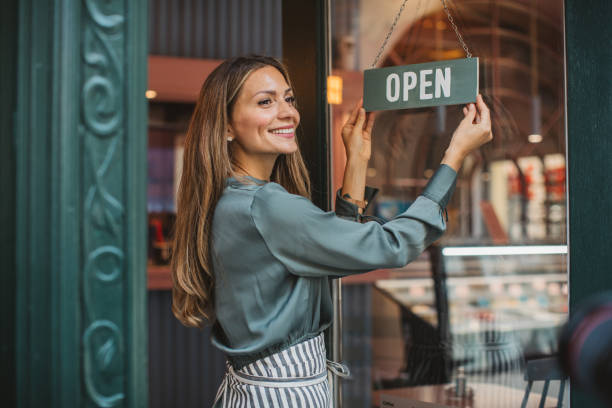 Small business owner Young woman owner of ice cream shop in town. She is opening her store and waiting for costumers. building entrance photos stock pictures, royalty-free photos & images