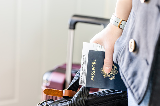 Una persona con identificación de ciudadanía estadounidense, pasaporte certificado vacunado y pertenencia personal lista para viajar en la nueva normalidad. photo