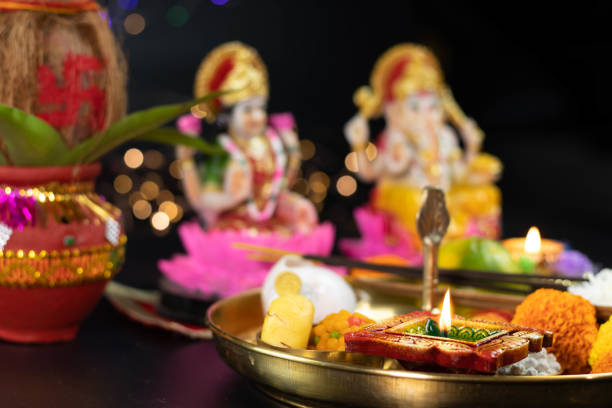 istock Clay Diya Deep Dia Lamp Lit in Pooja Thali With Flowers, Mithai, Agarbatti And Kalash In Front Of Maa Lakshmi And Bhagwan Ganesha Deva. Diwali Puja , New Year, Deepawali Or Shubh Deepavali 1346254732
