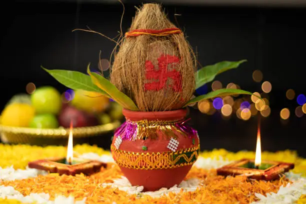 Terracotta Clay Kalash Decorated With Coconut, Mango Leaf Placed On Marigold Flower Rangoli With Diya Illuminating. Theme For Navratri Pooja, Dussehra Puja, New Home Inauguration And Shubh Deepavali