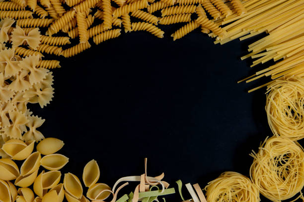 istock Assortment of different types of pasta dry on black background. 1346256730