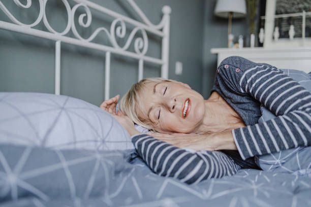 istock Senior woman is sleeping in bed at home 1346259384