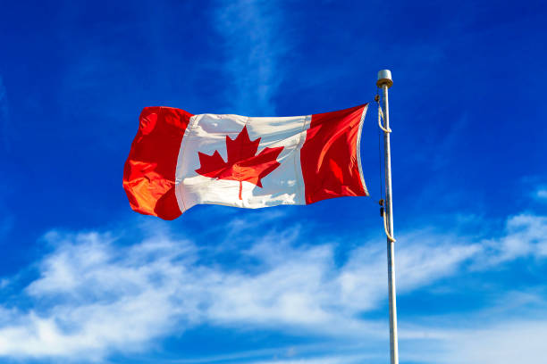 istock Canadian flag against blue sky 1346262130