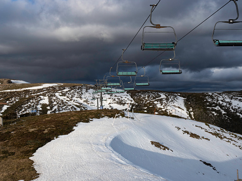 The end of the ski season and Mt Hotham, empty chair lift over disappearing snow