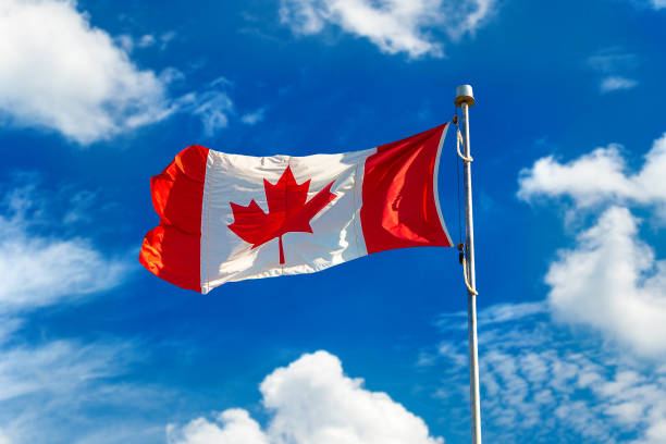 istock Canadian flag against blue sky 1346264065