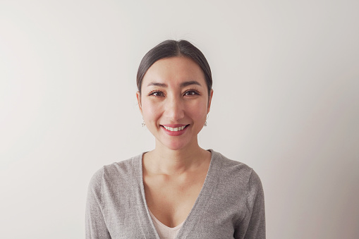 Head shot pov portrait of happy, confident and healthy mixed race Asian 30s woman smiling face