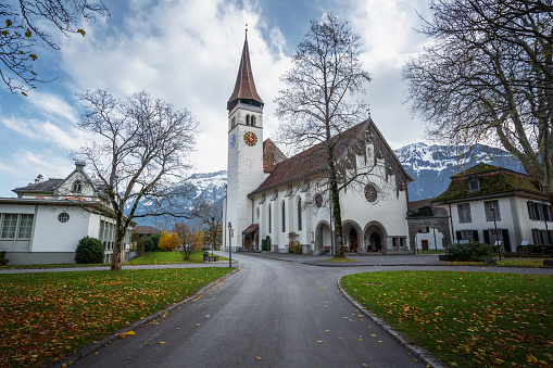 Fall landscape view of St. Valentin  Castelrotto Kastelruth Village Church on a sunny spring day with white flowers in the middle of a green valley surrounded by the Schlern mountains of the Italian Alps, Alto Adige, Italia