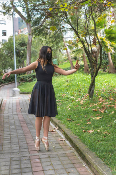 istock Ballet dancer with mask taking a selfie in a park 1346270486