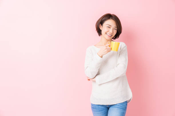 attraktive asiatische frau, die kaffee trinkt - coffee cup flash stock-fotos und bilder