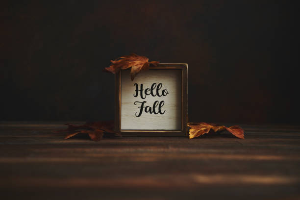 istock Hello Fall Sign with Leaves on Rustic Wood Background 1346279899