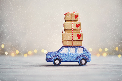 Cute Blue Glitter Car Driving in Snow with Christmas Gifts on Roof