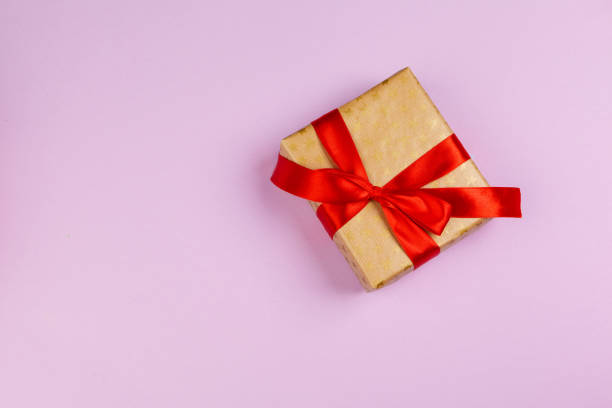 istock Top view of a decorated present with a bow on pink background 1346280875