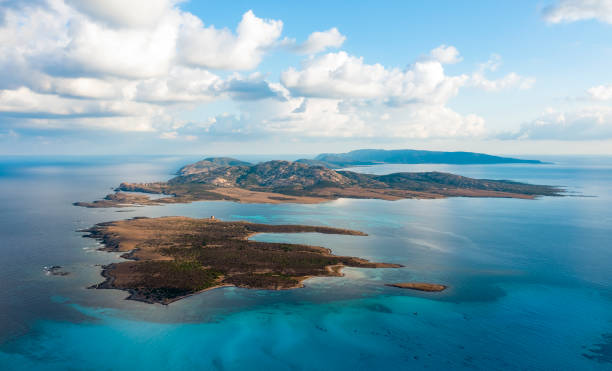 vista desde arriba, impresionante vista aérea de la isla de asinara bañada por un agua turquesa. asinara es una pequeña isla deshabitada que se encuentra frente a la costa noroeste de cerdeña, italia. - sea high angle view water tranquil scene fotografías e imágenes de stock