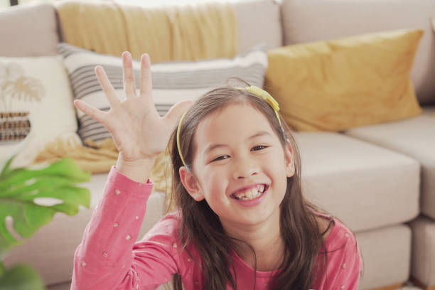 istock Mixed Asian girl making video calling with laptop at home, using zoom online virtual class , social distancing, homeschooling, remotely  learning during covid pandemic, new normal concept 1346285208