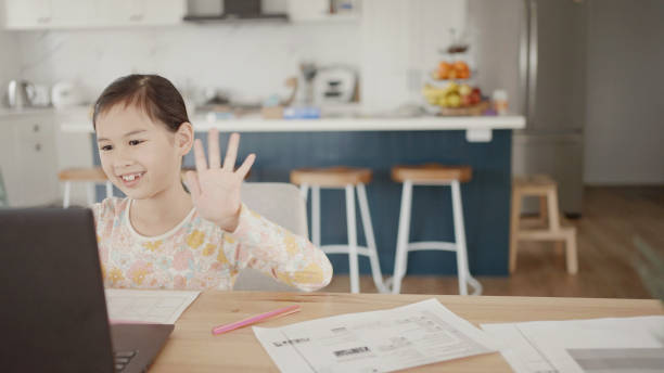 istock Mixed Asian girl making video calling with laptop at home, using zoom online virtual class , social distancing, homeschooling, remotely  learning during covid pandemic, new normal concept 1346285228