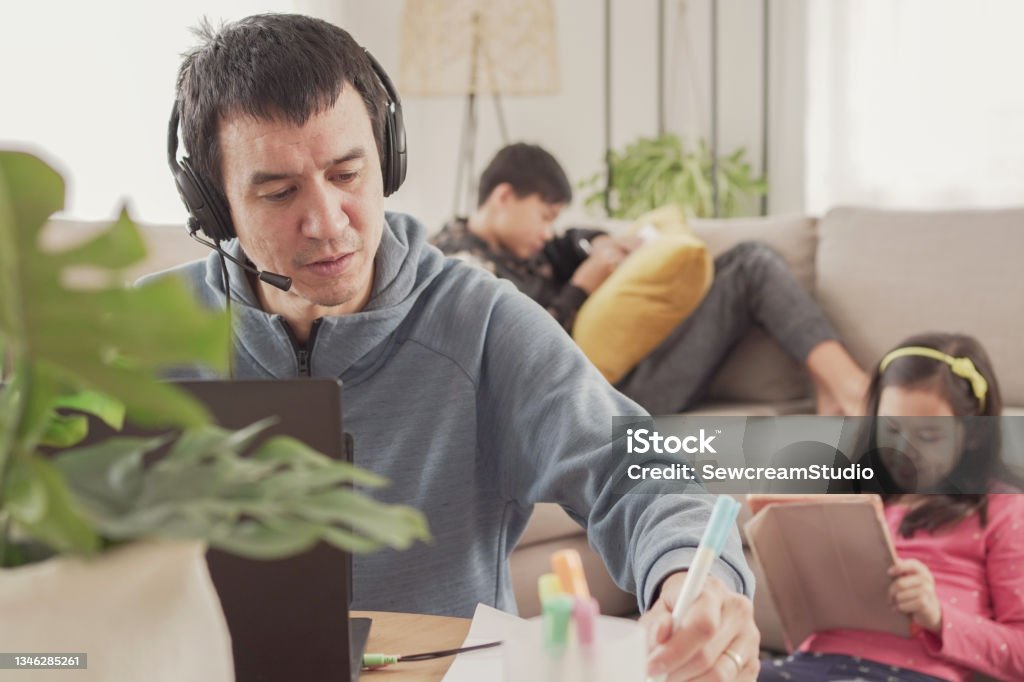 Father working from home with children. Homeschooling, stay home, social distancing during covid pandemic , freelance job, new normal concept Working At Home Stock Photo