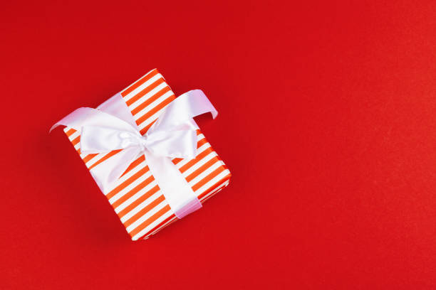 istock Wrapped gift box on a red background, view from above 1346288942