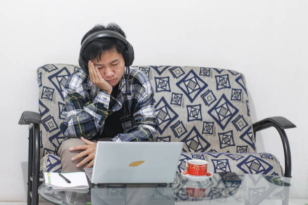 istock Asian male working at home using laptop video conference call meeting with headset 1346290906