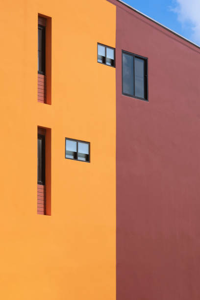 istock various fixing glass windows on orange and brown modern building wall with blue sky 1346291133