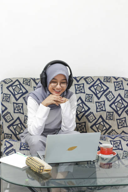 istock Asian female working at home using laptop video conference call meeting with headset 1346293370