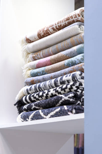 istock Textile industrial background with fabric texture, variation of multicolored soft cotton carpets and warm blankets stacked neatly on a shelf in a closet. Organization of space and order at home 1346293454