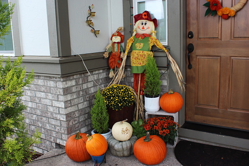 Fall decorations with pumpkins, mums at front door