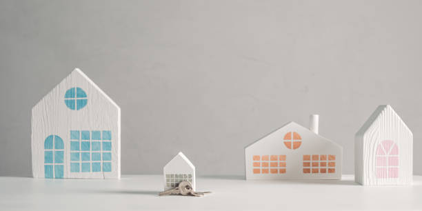 istock Little white house model with keys among a small town or suburb 1346297421