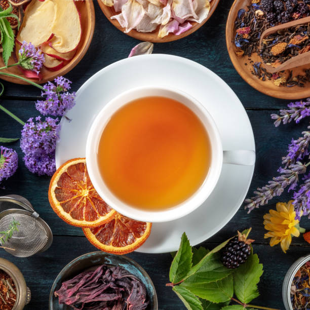 차, 오버 헤드 사각형 샷. 차 한 잔 주위에 나뭇잎, 꽃, 과일 - lavender orange fruit table 뉴스 사진 이미지