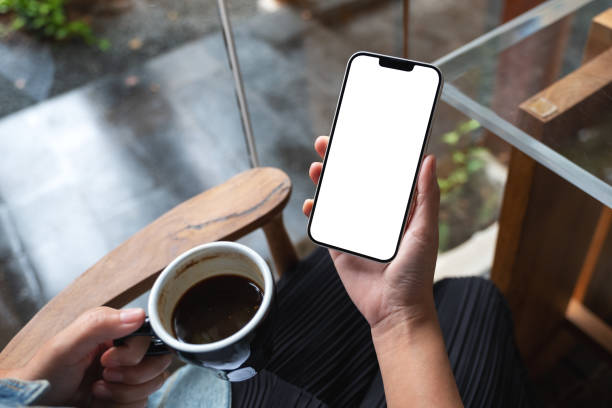 istock A woman holding mobile phone with blank desktop screen while drinking coffee 1346298795