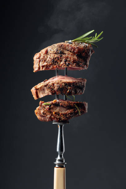 istock Hot steak with smoke on a black background. 1346299385