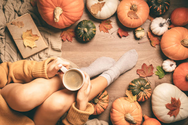 istock woman sitting between pumpkins 1346299835