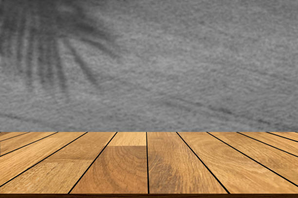 istock Wooden table with blurred dark gray marble wall and coconut leaf shadow background. Can be used for display or montage for show your products. 1346300806