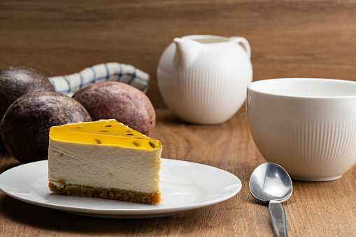 View of delicious homemade passion fruit cheesecake in white ceramic dish.