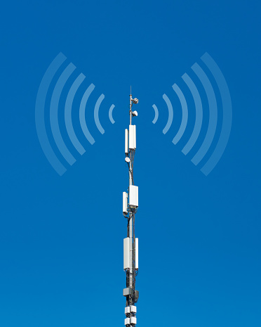 Telecommunication cell tower antenna against blue sky background. Wireless communication and modern mobile internet. Radio emission