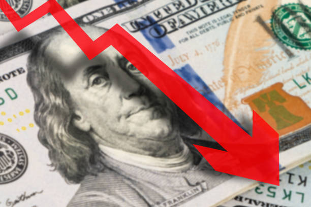 istock Business chart with red arrow down and dollars background, dollar rate falling 1346310146