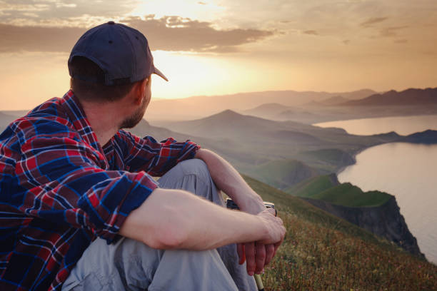 istock Confident man sitting and enjoying view in hilly landscape 1346310988