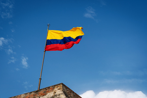 The Colombian national flag in front of blue sky