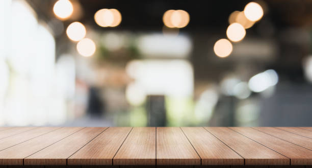 istock Empty wooden table top with lights bokeh on blur restaurant background 1346313564