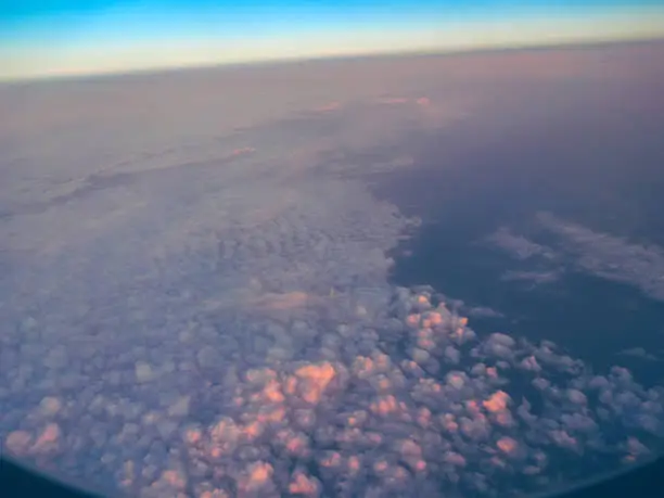 View of the clouds from the plane's window - clouds in the first rays of the sun
