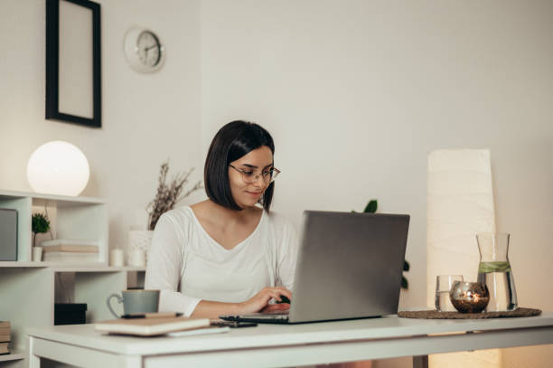 istock Beautiful woman using a laptop while working from home 1346315878