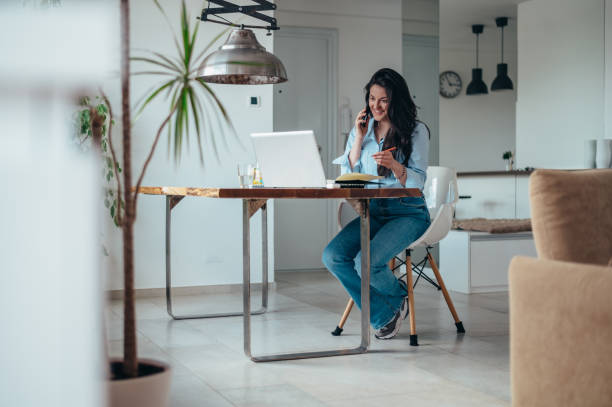 istock Businesswoman using a laptop and a smartphone while working from home 1346315901